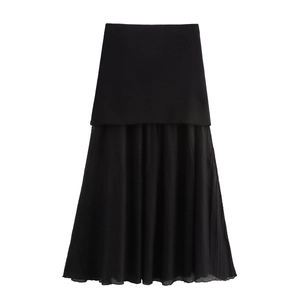 Detail of black knit dress featuring a pleated chiffon patchwork hem and smooth fabric