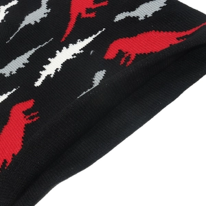 Black knit beanie with red and white dinosaur silhouette pattern and ribbed edge