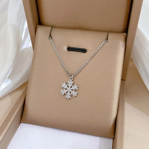 Detailed view of a silver snowflake pendant with sparkling zircons in a jewelry box