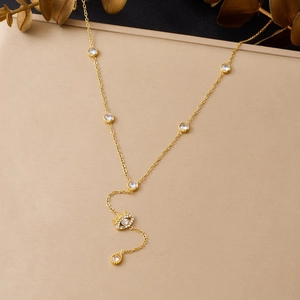 Détail du collier lasso doré en Y avec pendentif œil en zircone et breloque goutte
