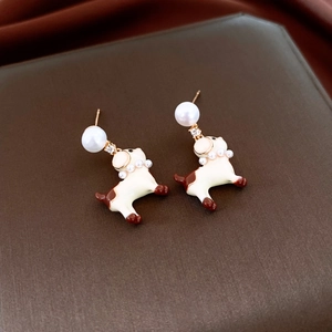 Vue détaillée de boucles d'oreilles chien avec perles blanches et zircons brillants
