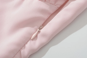 Detailed macro view of pink fabric texture and high-quality invisible zipper on the dress