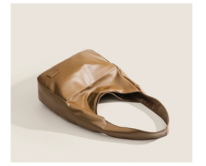 Detail view of smooth caramel brown PU leather texture on a spacious tote bag