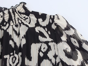 Detail of smocked high neckline and gold lurex stripes on lightweight chiffon dress