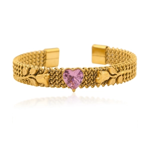 Detail of gold-plated rose bracelet with pink heart-shaped crystal on white background