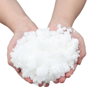 Artificial white snow powder for Christmas tree decoration held in hands for realistic texture