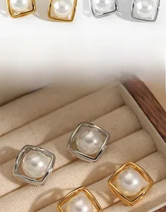 Detail of square frame pearl earrings in gold and silver with high polish PVD plating