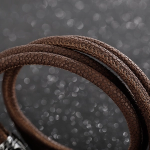 Macro detail of brown textured leather wrap bracelet with premium pebble grain stitching