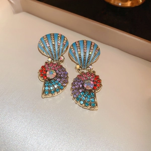 Detail of shell-shaped gold earrings with colorful rhinestones and blue enamel inlay