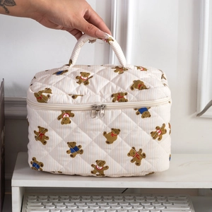 Close-up of quilted bear print makeup bag with reinforced handle and dual zippers