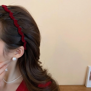 Detail of red flocked wavy headband paired with elegant pearl earrings and necklace