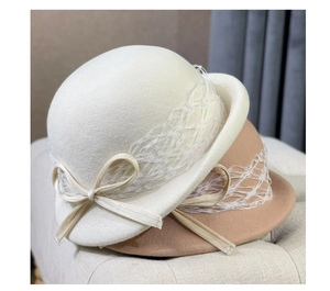 Close-up of wool cloche hats in beige and camel with lace ribbons and bows