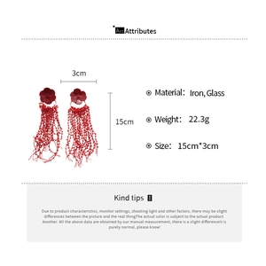 Detailed view of red floral glass beaded fringe earrings with iron and glass material specs