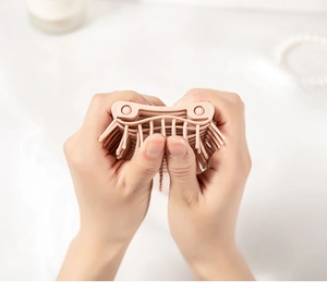 Close-up of pink flexible curved hairbrush showing high elasticity and mesh structure