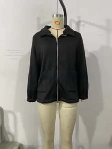 Close-up of black short jacket featuring lapel collar, metal zipper, and cargo style pockets