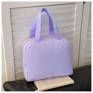 Detail view of a purple waterproof canvas lunch bag with durable nylon handles