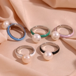 Detail of colorful enamel pearl rings in light blue, green, pink, black and white set