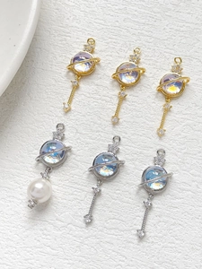 Detail of 14k gold and silver Saturn planet charms with opals and pearls for DIY jewelry