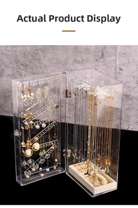 Macro view of clear acrylic jewelry box with multi-layer hooks and velvet slots
