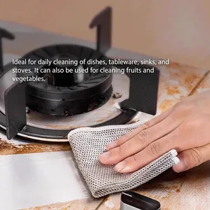 Silver metal wire dishcloth for kitchen cleaning with thick edges on a stovetop