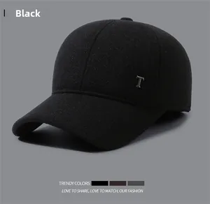 Detail of black wool winter baseball cap with metal T letter and thick textured fabric