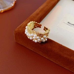 Dettaglio anello placcato oro con perle incastonate e design aperto regolabile chic