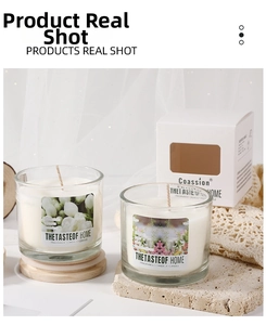 Close-up of glass jar scented candles with wood lids and a white branded gift box