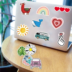 Colorful VSCO aesthetic PVC waterproof stickers on a silver laptop and wooden table
