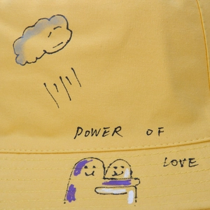 Yellow reversible cotton bucket hat with Power of Love graffiti for outdoor sun protection