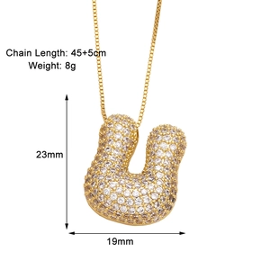 Detail view of gold letter U pendant necklace with dimensions and zircon inlay