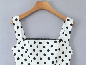 Detail of white polka dot dress neckline with delicate black lace trim detailing