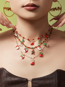 Détail d'un collier de perles de Noël à plusieurs rangs et boucles d'oreilles festives