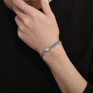 Detail of silver Cuban chain bracelet with lobster clasp and matching ring on model