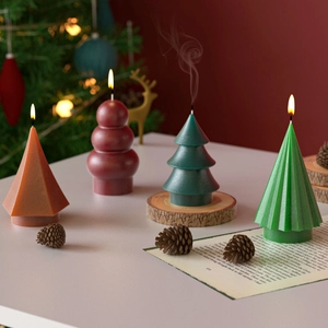 Dettaglio di candele a forma di albero di Natale a strisce e decorazioni in resina