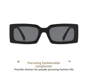 Close-up of modern thick-frame rectangular sunglasses with dark lenses on white background