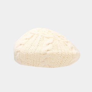 Close-up of cream cable knit beret showing textured wool pattern and soft material