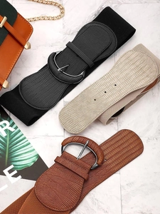 Detail of wide elastic waist belts in black, beige and brown with crocodile pattern leather