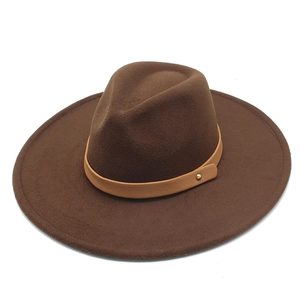 Macro detail of dark brown wool fedora hat with light brown leather band and metal stud
