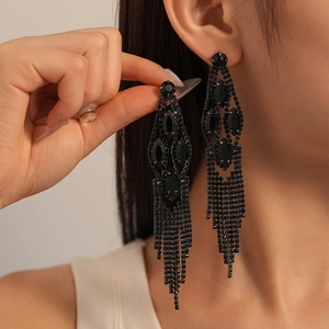 Close-up of black geometric tassel earrings with rhinestones on a female model