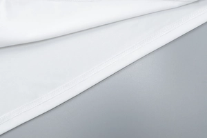 Vue macro de l'ourlet du haut blanc avec coutures professionnelles et tissu lisse