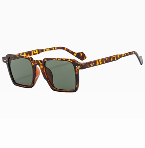 Detail view of tortoiseshell square sunglasses featuring double metal studs and dark lenses