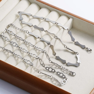 Detail of silver bone-shaped and hollow hexagonal link chains in a velvet jewelry box