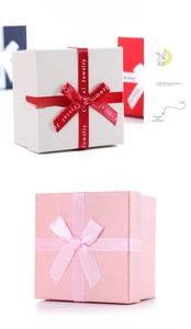 Detail view of pink and white jewelry boxes featuring textured finish and ribbon bows