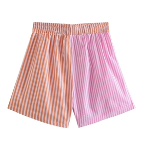 Detail of high-waisted shorts featuring asymmetrical orange and pink vertical stripes