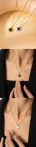 Détail du pendentif trèfle avec onyx noir et nacre blanche sur une chaîne dorée