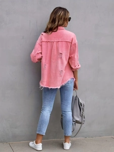 Close-up of pink denim jacket back showing frayed edges and distressed ripped details