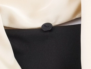 Detail showing high-quality twill fabric texture and button on colorblock blazer jacket