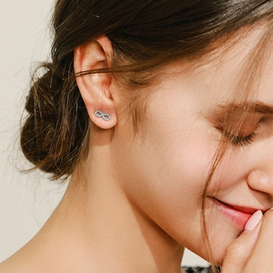 Elegant S925 sterling silver infinity earrings with turquoise stone worn by a model