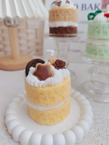 Macro shot of tiered yellow sponge cake candle with cream and star chocolate