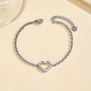 Vista macro del bracciale a cuore in acciaio argento con incisione LOVE e piccoli strass
